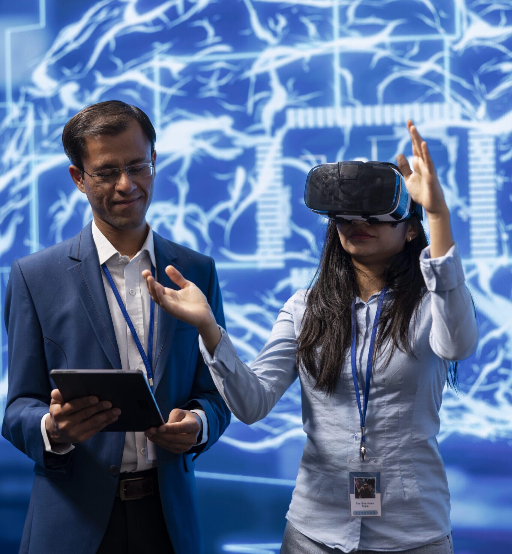 Mujer utilizando gafas de realidad virtual durante una demostración acompañada por un experto con tablet