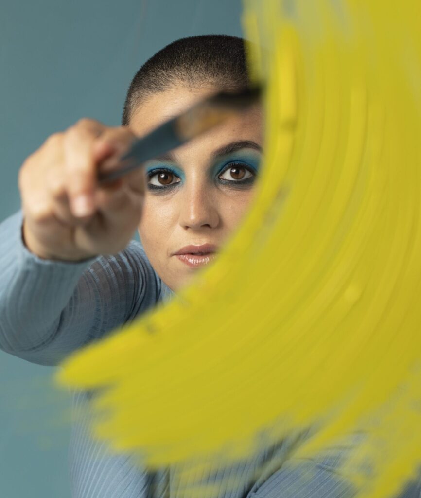 Mujer aplicando trazo amarillo simbolizando rediseño de marca